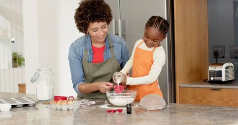 Diverse Mother and Daughter Baking Together in Cozy Kitchen