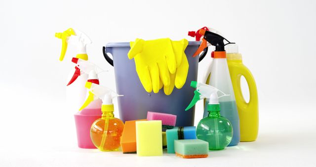 This image depicts an assortment of cleaning supplies and equipment, including spray bottles, sponges, gloves, a bucket, and a detergent bottle set against a white background. The image can be used in contexts such as cleaning service advertisements, household cleaning tips blogs, eco-friendly cleaning product promotions, and organization and cleaning related content.