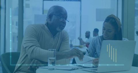 Mentor guiding young professional at coworking space