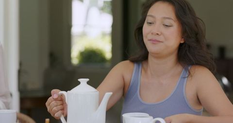 Woman Pouring Tea at Outdoor Gathering Celebration