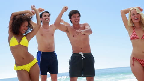 Group of Friends Joyfully Dancing on Beach