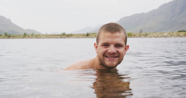 Man enjoying swim in mountain lake with smile - Download Free Stock Photos Pikwizard.com