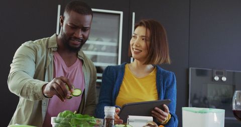Diverse Couple Sharing Kitchen Time and Cooking with Tablet