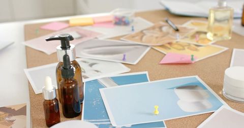 Beauty Brand Moodboard with Amber Glass Bottles and Printed Swatches on Corkboard