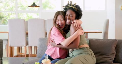 Joyful Celebration at Home with Mixed Ethnicity Couple Hugging