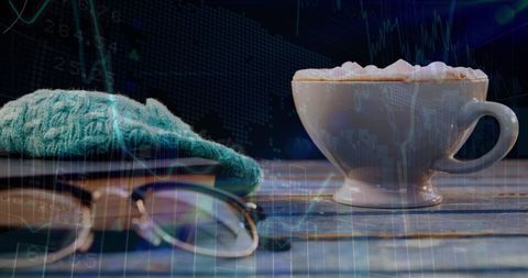 Financial Graphs Over Coffee Cup and Book Scene