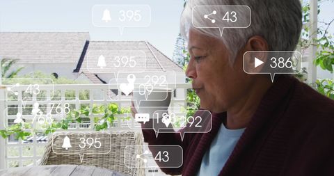 Senior biracial influencer engaging on social media while relaxing outdoors