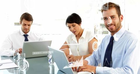 Business team collaborating with digital analytics overlays, smiling executive at laptop