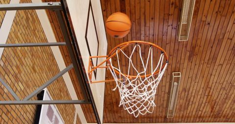 Basketball in Mid-Air Near Hoop during Game Indoors