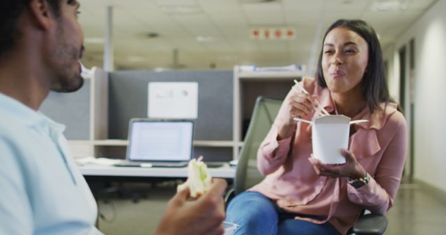 Image of happy diverse businesswoman and businessman eating and talking in office. business professionals and working in office concept.