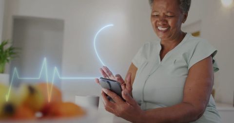 Happy Senior Woman Engaging with Smartphone for Health Monitoring