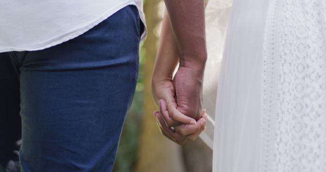 Close up of married african american couple holding hands. Wedding day, marriage and celebration concept.