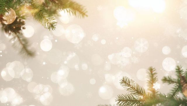 Warm golden bokeh background framing evergreen pine branches with glass ornament