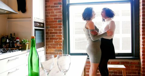 Lesbian Couple Embraces in Cozy Kitchen