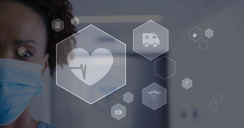 Masked nurse wearing scrubs observing virtual medical icons in clinic corridor