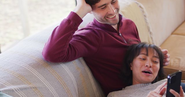 Image of back view of happy diverse couple sitting on sofa and talking - Download Free Stock Photos Pikwizard.com