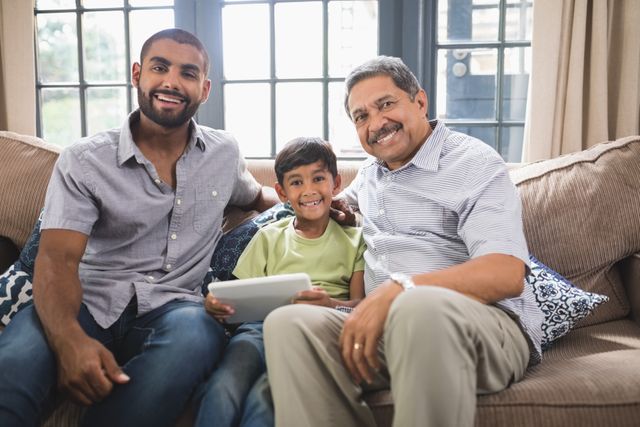 Portrait of smiling multi-generation family sitting together on couch at home
