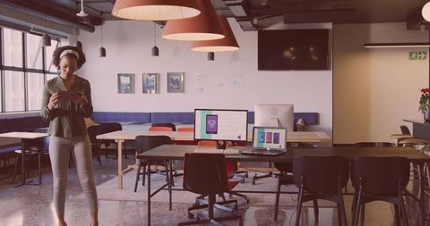 Businesswoman using smartphone in modern coworking office