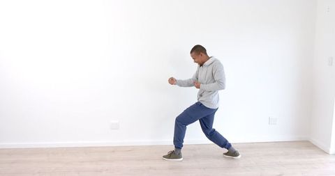 Man Practicing Martial Arts at Home in Casual Sportswear