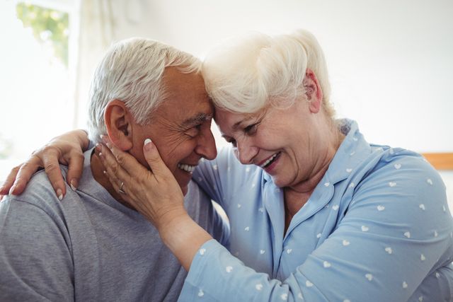 Senior couple embracing each other in bedroom