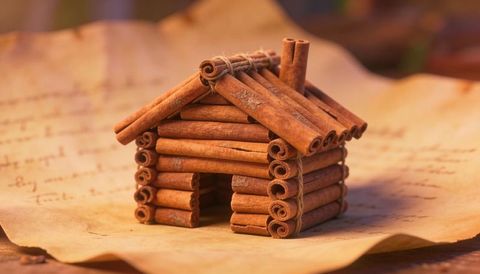 Handcrafted cinnamon stick cabin on parchment rustic miniature log house holiday decor