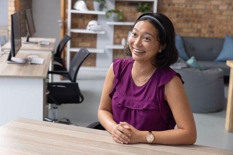 Asian Woman in Modern Open-Plan Office Smiling Joyfully