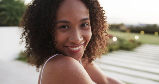 Smiling Woman with Curly Hair Looking at Camera Outdoors - Download Free Stock Images Pikwizard.com