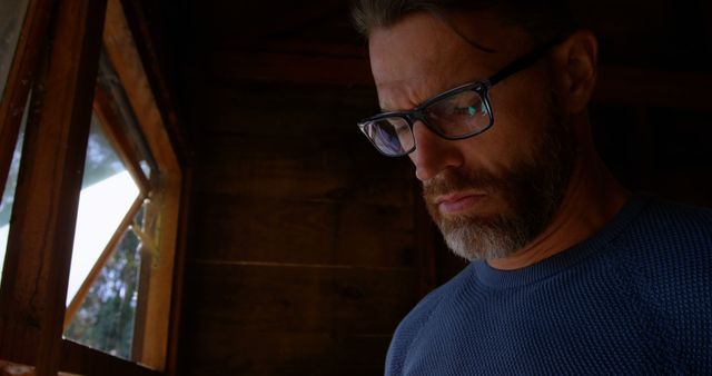 Focused Man with Glasses in Warm Cottage - Download Free Stock Images Pikwizard.com