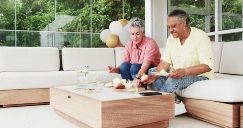 Senior Lesbian Couple Enjoying Cake and Celebration Outdoors