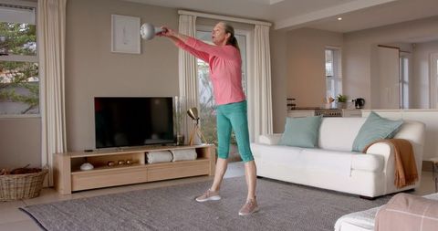 Senior Woman Exercising with Kettlebell in Inviting Living Room