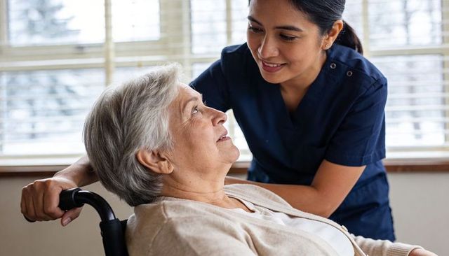 Compassionate caregiver assisting senior woman in wheelchair during warm daytime care
