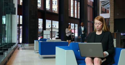 Focused Businesswoman Using Laptop in Modern Office Lobby - Download Free Stock Images Pikwizard.com