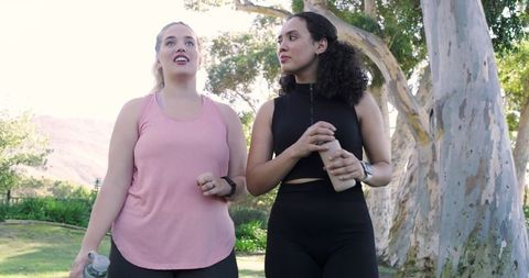 Diverse Female Friends Exercising Outdoors with Water Bottles