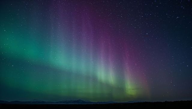 Aurora curtains dancing over mountain silhouette and starlit horizon vivid green magenta