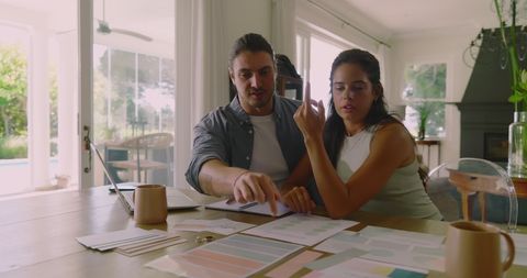 Couple Plans Wedding with Documents at Home in Sunlit Environment