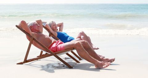 Senior Couple Relaxing at Beach in Summer Sunshine - Download Free Stock Images Pikwizard.com