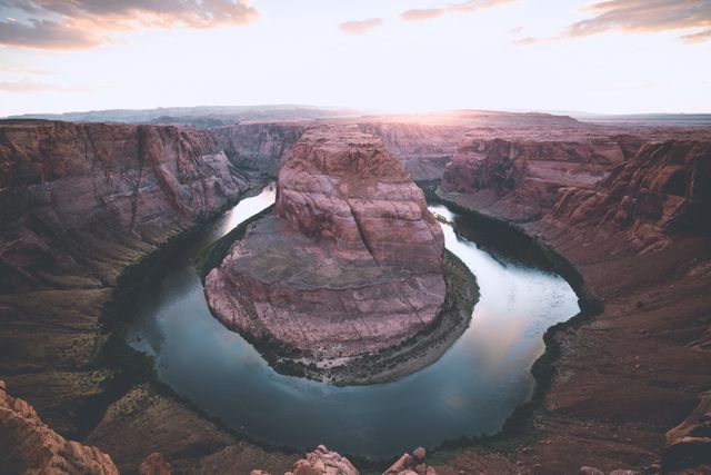 Horseshoe Bend at sunset showcasing stunning panoramic views of the winding Colorado River and rugged canyon cliffs. Ideal for use in travel magazines, tourism websites, nature documentaries, and landscape art prints.