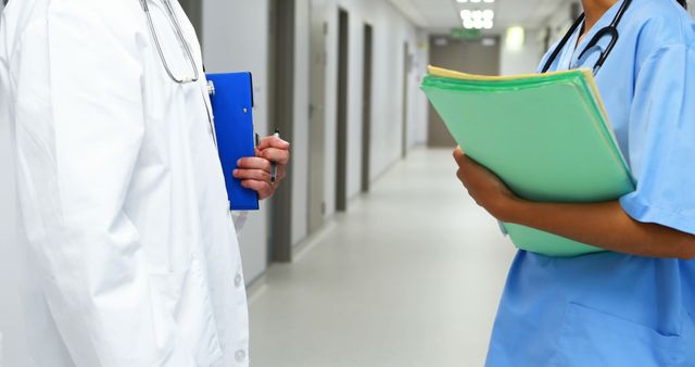 Healthcare Professionals Holding Medical Records in Hospital Corridor - Download Free Stock Images Pikwizard.com