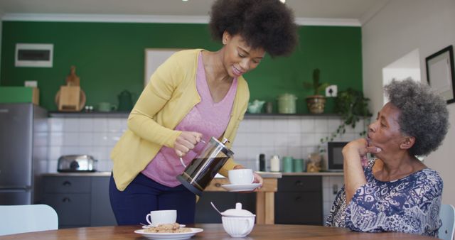 Woman Pouring Coffee for Elderly Woman in Modern Kitchen - Download Free Stock Photos Pikwizard.com