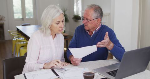 Senior Couple Budgeting Finances at Home with Laptop