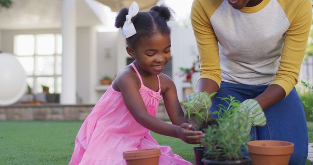 Happy african american mother and daughter gardening, planting plants in garden - Download Free Stock Photos Pikwizard.com