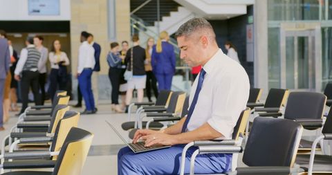 Businessman Using Laptop at Seminar in Modern Office Lobby - Download Free Stock Images Pikwizard.com