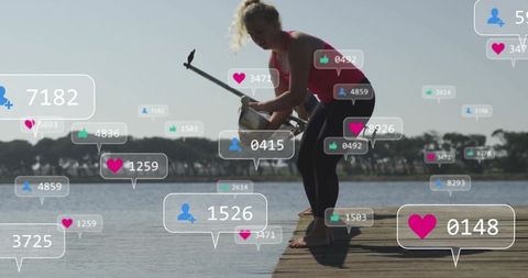 Woman paddleboarding on lake with social media engagement