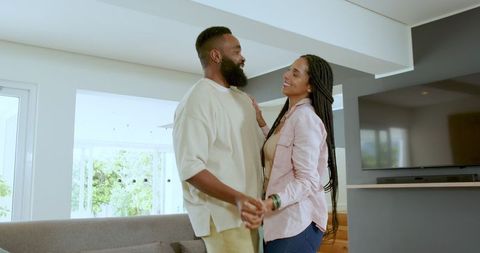Happy Couple Dancing and Smiling in Sunlit Living Room