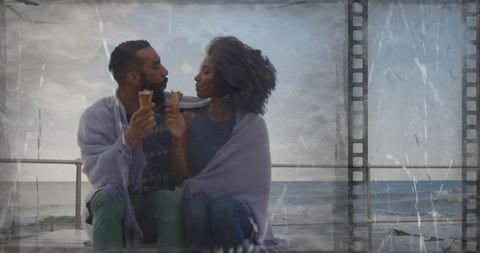 Romantic couple sharing ice cream by the seaside