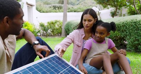 Family Exploring Solar Panel as Green Energy Solution in Backyard