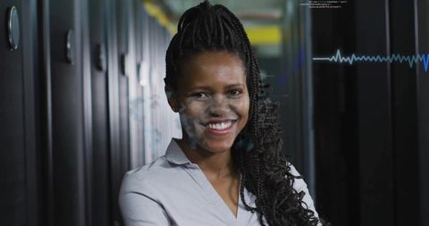 Smiling woman standing in data center aisle with waveform overlay, IT technician portrait
