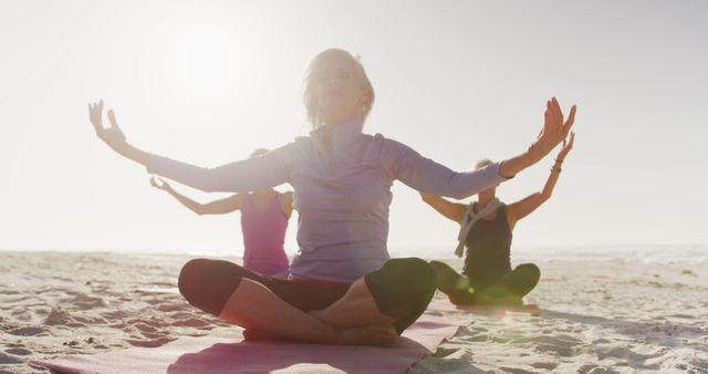 Diverse women wearing sports clothes doing yoga and meditating at beach - Download Free Stock Photos Pikwizard.com