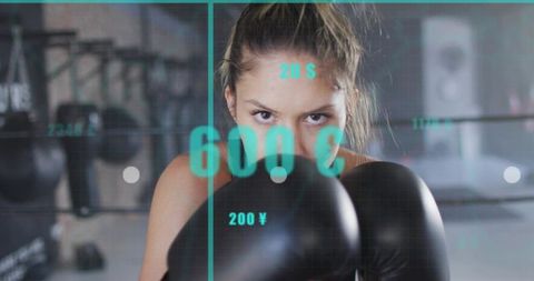 Female boxer raising guard and staring through gloves with teal hud overlay
