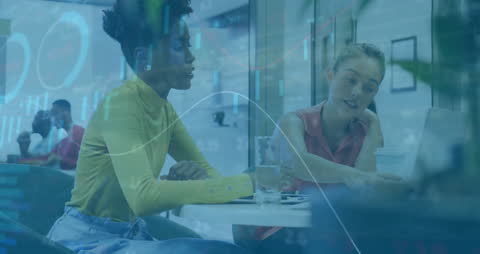 Diverse Female Colleagues Analyzing Financial Data in Office